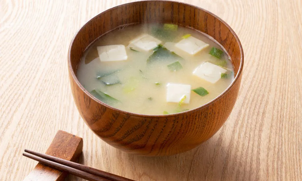 Hot miso soup with tofu, seaweed, and green onions in a wooden bowl at Tokyo Express, a Japanese Restaurant in Greenville