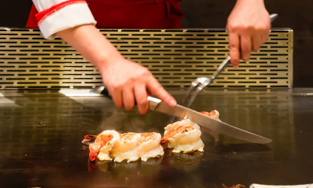 Teppanyaki chef cooking shrimp on a hot iron griddle at Tokyo Express, a Japanese Restaurant in Greenville